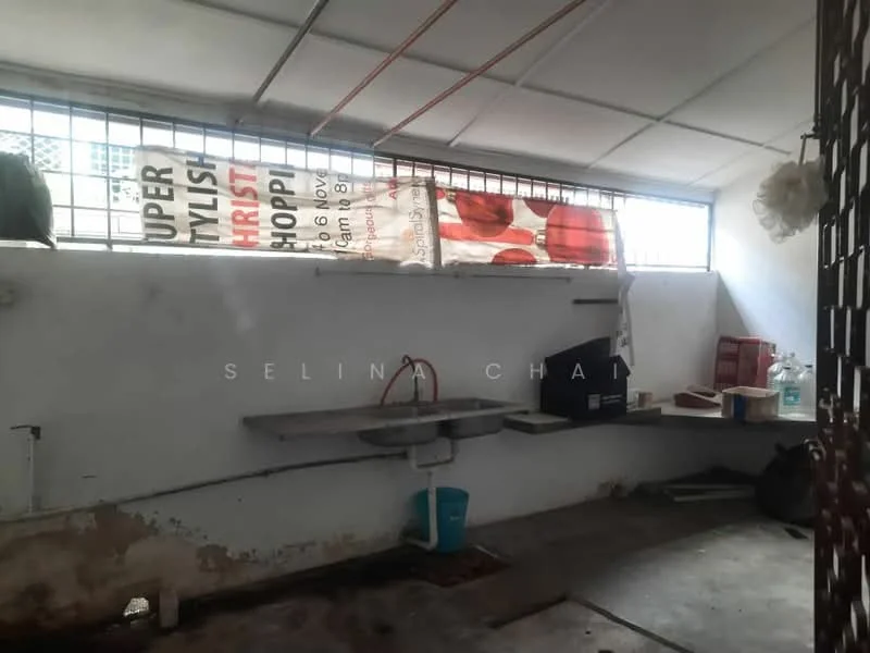 Room features: concrete flooring, white walls, metal grating windows, shelves against the wall, sink, water container, banners on the wall.