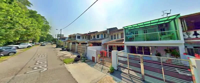 Exterior type: linked terrace house; features: two-storey linked terrace houses, glass balcony on upper floor, painted facade in pastel colors, front yard with low fence, driveway with interlocking pavers, street view with trees, visible street name 'Jalan Masai', sidewalk along the street; style: modern.