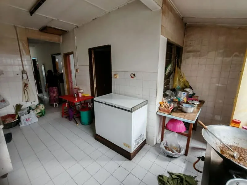 Kitchen features: white tiled walls, white tiled flooring, double-door freezer, wooden countertop, sink, stainless-steel pot, plastic storage containers, cooking utensils, green plastic chair, dining table with chairs.