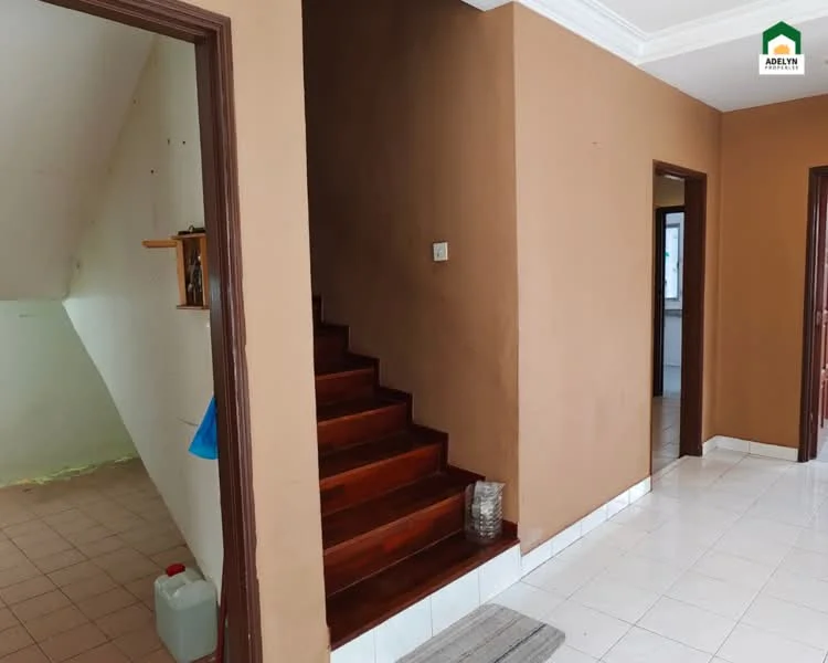 Room features: brown painted walls, white tiled flooring, wooden staircase, recessed ceiling, doorway leading to another room, shelf on wall, light switch, decorative glass vase; style: modern.