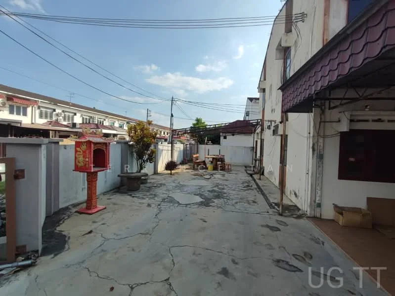 Exterior type: linked terrace house; features: concrete driveway, white painted walls, red Chinese altar, mature tree, overhead power lines, surrounding residential buildings, open space, partially paved area; style: traditional.