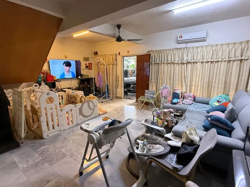 Living features: grey fabric sectional sofa, marble flooring, 5-blade ceiling fan, wall-mounted TV, wooden door, curtains with tiebacks, playpen, baby high chair, decorative cushions, various children's toys, coffee table, area rug; style: modern.