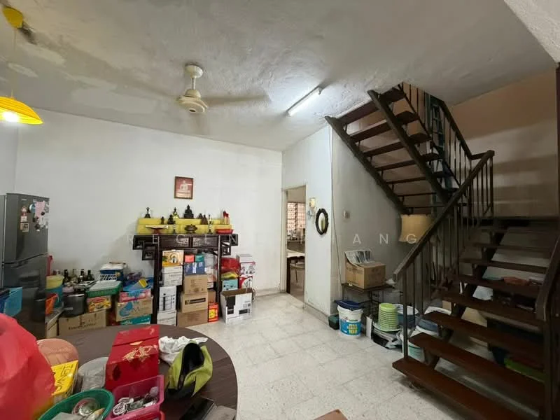 Room features: white painted walls, textured ceiling, ceiling fan, tile flooring, wooden staircase, wooden handrail, dining table, refrigerator, storage boxes, decorative items on shelves, open doorway to kitchen, various kitchenware visible.