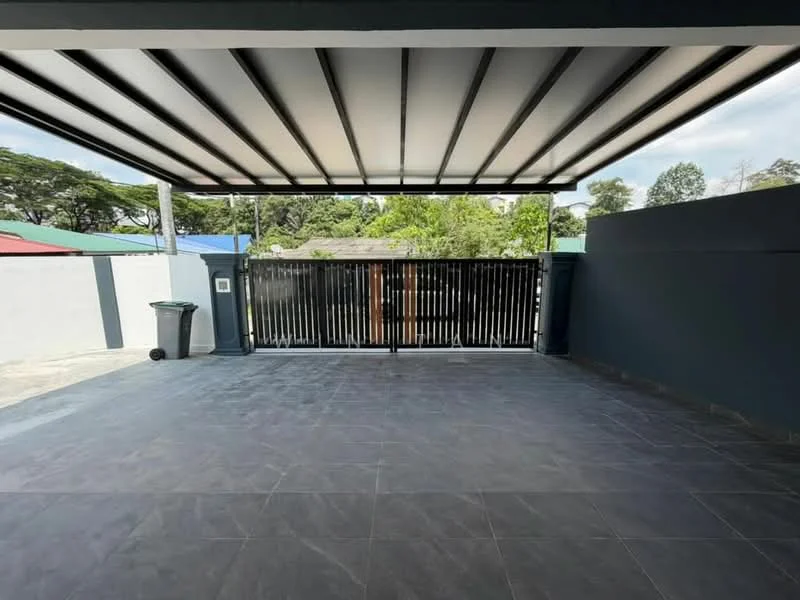 Exterior type: car porch; features: covered car porch with metal roof, grey tiled flooring, black vertical slatted gate, surrounded by greenery, concrete wall, manicured landscaping visible in background; style: modern.