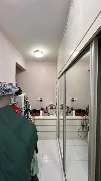 Room features: light grey painted walls, white tiled flooring, built-in wardrobe with sliding mirror doors, vanity with sink, overhead lighting fixture, clothing rack with hanging clothes, multiple bottles and toiletries on vanity, shelves with various items; style: modern.