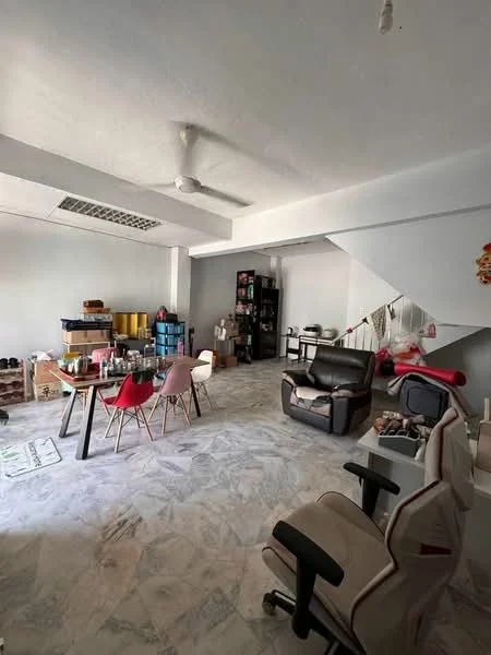 Room features: marble flooring, white painted walls, ceiling fan, dining table with chairs, multiple storage boxes, shelves with items, staircase, various seating chairs.