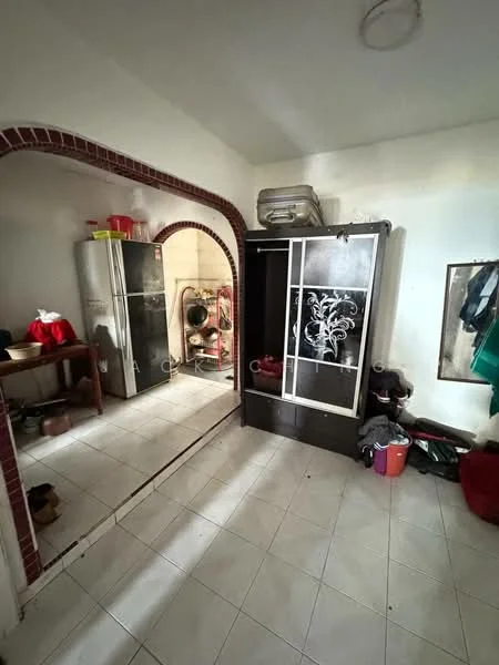 Room features: white tiled flooring, arched entryway, dark wood cabinet, stainless-steel fridge, wall-mounted mirror, various kitchen utensils, plastic storage containers, clothing hanging on wall.