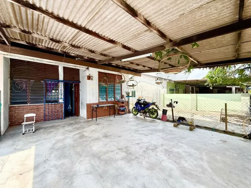 Exterior type: detached bungalow; features: corrugated metal roof, concrete flooring, exposed brick wall, wooden window shutters, outdoor space with seating area, fenced yard, motorbike parked, hanging plants, open-air design, surrounded by greenery; style: traditional.