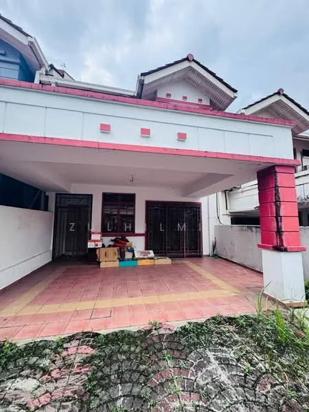 Exterior type: semi-detached house; features: red and white painted facade, pitched tile roof, covered car porch, brick paving on driveway, manicured lawn, front entrance with double doors, visible storage boxes, surrounding residential area; style: traditional.