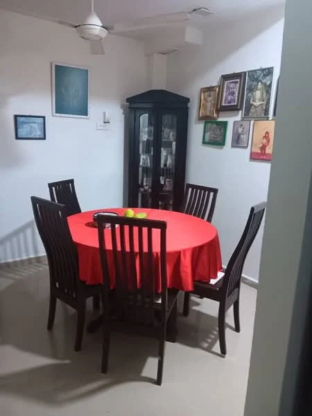 Dining features: round dining table with red tablecloth, 6 wooden dining chairs, ceiling fan, white painted walls, framed artwork on walls, glass display cabinet, decorative items on cabinet, laminate flooring; style: traditional.