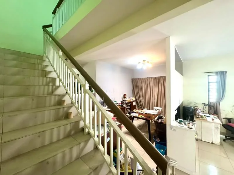 Room features: staircase with wooden railing, cream painted walls, tile flooring, ceiling light fixture, large window with curtain, cluttered workspace with desk, various furniture pieces, open layout.