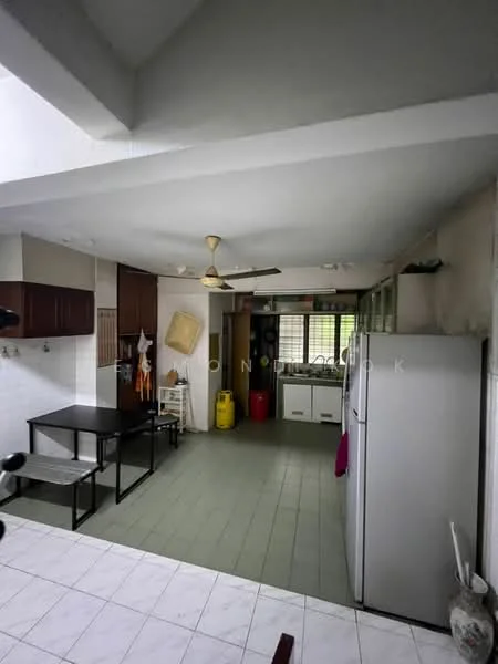 Kitchen features: white painted walls, grey ceiling, green tile flooring, brown wooden cabinets, stainless-steel fridge, black dining table with metal legs, ceiling fan, window with metal grille, sink with faucet, yellow gas cylinder, green countertop, built-in kitchen shelves.
