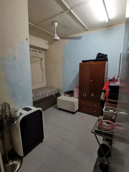 Room features: single bed, wooden wardrobe, white walls with blue accent, ceiling fan, tile flooring, window with blinds, air conditioning unit, small bedside table, clothes rack.