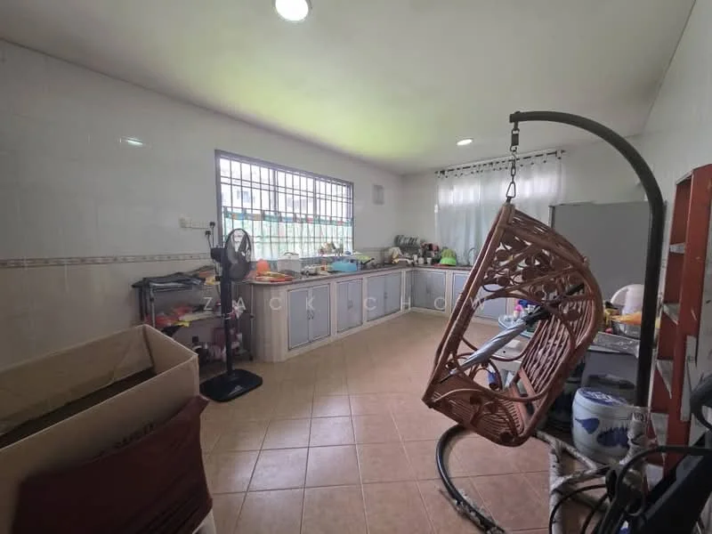Kitchen features: grey cabinetry, white tiled walls, brown tiled flooring, window with grid pattern, hanging rattan chair, kitchen counter with clutter, multiple kitchen appliances visible, sink, ceiling lights.