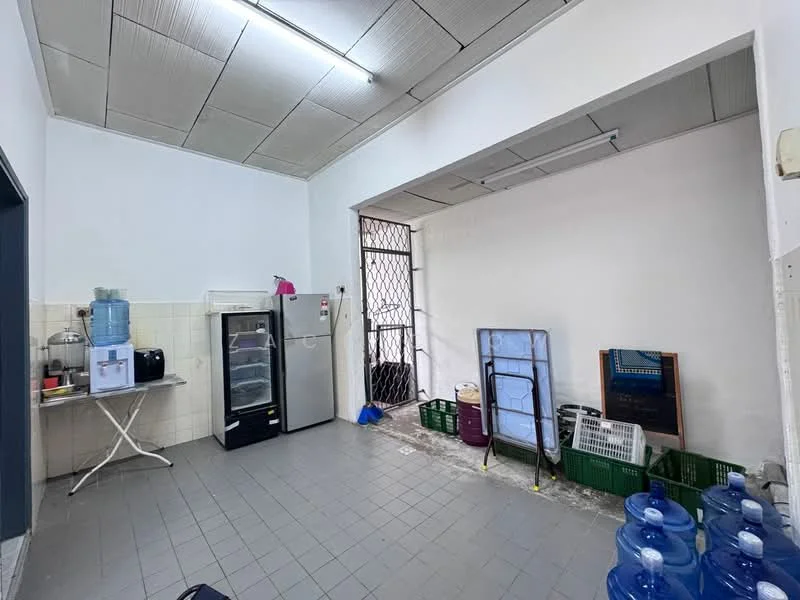 Laundry features: grey tiled flooring, white painted walls, metal shelving unit, water dispenser, black fridge, folding table, window with security grille, plastic storage baskets, mirror, multiple blue water bottles.