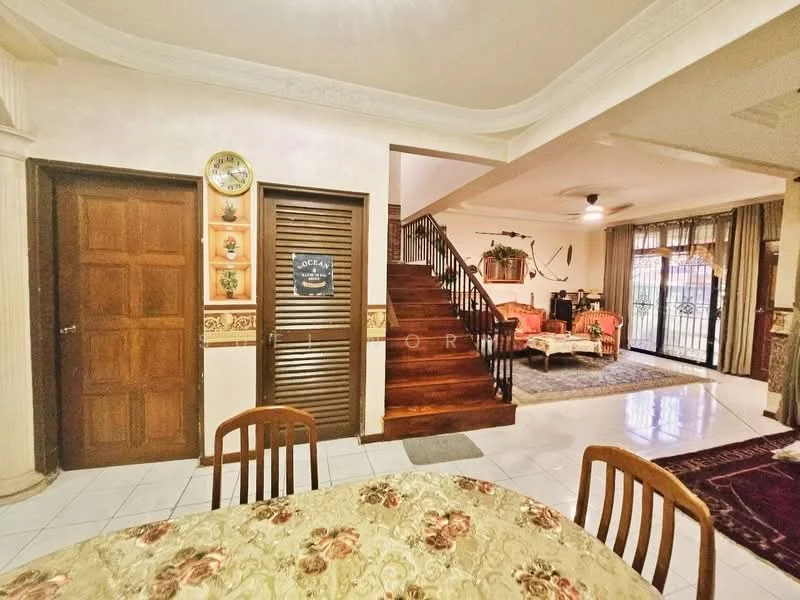 Dining features: round dining table with floral tablecloth, wooden dining chairs, white tiled flooring, decorative wall clock, wooden door, wooden louvered door, wall with decorative trim; style: traditional. Living features: sofa set in beige, coffee table, area rug, curtains, staircase with wooden steps, wall-mounted decor, large windows, ceiling fan; style: traditional.
