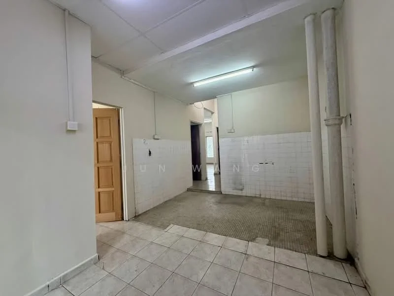 Room features: white painted walls, tile flooring, fluorescent ceiling lights, exposed pipes, empty space, wall tiles, doorway leading to another room, window with natural light.