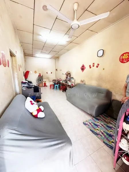 Living features: light-colored painted walls, white tiled flooring, dropped ceiling, 5-blade ceiling fan, 2 fabric sofas in grey, decorative wall clock, colorful wall decorations, area rug with geometric pattern, small table with various items, stuffed toy on sofa.