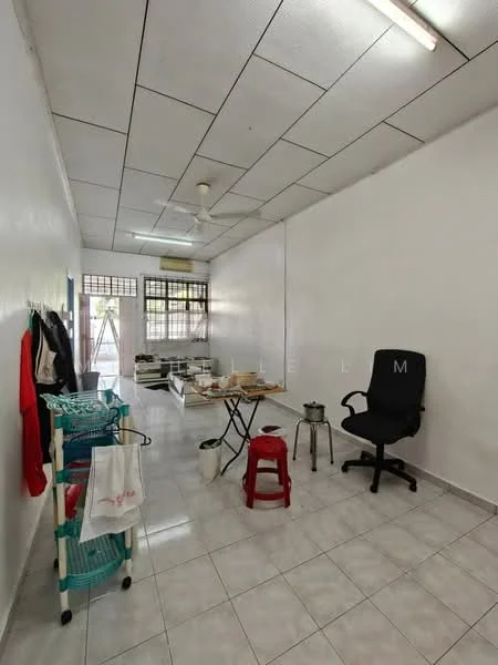 Room features: white painted walls, white tiled flooring, ceiling with fluorescent lighting, ceiling fan, window with grid pattern, wooden table, black office chair, red stool, metal pot, rolling cart with towels, open space layout; style: minimalist.