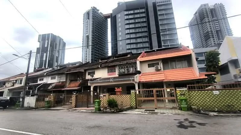 Exterior type: linked terrace house; features: two-storey linked terrace houses, orange tiled roof, white painted facade, wooden fencing, green trash bins, paved walkway, surrounded by high-rise buildings, urban context with city skyline in background; style: traditional.