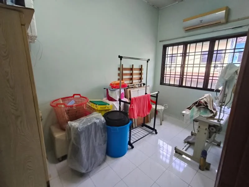 Laundry features: light green painted walls, white tiled flooring, window with metal grille, wall-mounted air conditioning unit, clothes drying rack, plastic laundry basket, black trash bin, stack of plastic storage boxes, ironing board, clothes hanging on a rack.