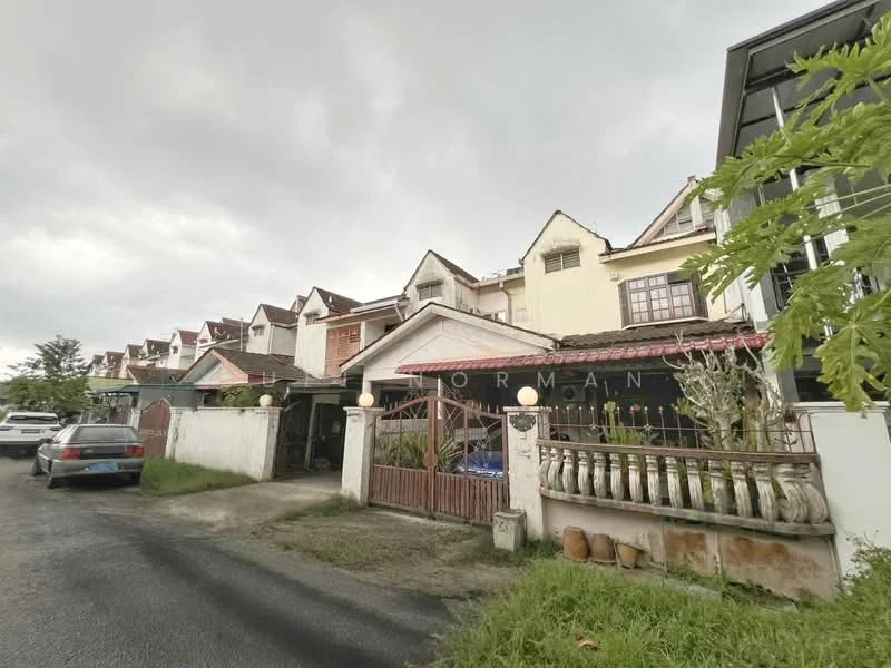Exterior type: linked terrace house; features: two-storey building, red tiled roof, white painted facade, front porch with railing, manicured lawn, paved driveway, multiple gabled roofs, surrounded by greenery, visible car parked in driveway, fenced front yard; style: modern.