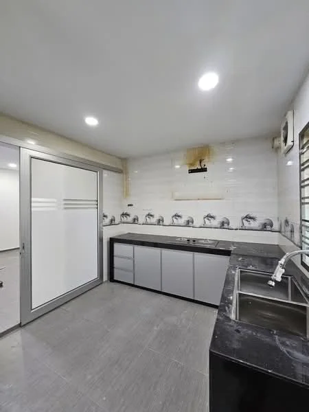 Kitchen features: grey cabinetry with flat-panel design, black granite countertop, double-bowl stainless-steel sink, chrome pull-down faucet, white tiled backsplash with decorative border, recessed LED downlights, sliding glass door, grey ceramic tile flooring, wall-mounted air conditioning unit; style: modern.