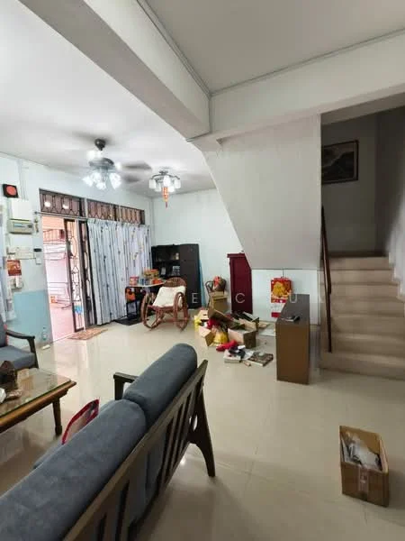 Living features: cream tiled flooring, white painted walls, ceiling fan with light, sofa with wooden frame, wooden coffee table, TV console, decorative wall art, staircase leading to upper floor, open space layout, cluttered with boxes and items.