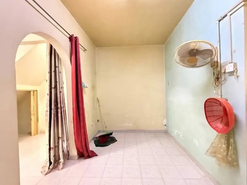 Room features: light green painted walls, cream painted ceiling, white tiled flooring, 5-blade ceiling fan, curtains in red and floral patterns, broom and dustpan on the floor, plastic basket hanging on the wall, wall-mounted electrical outlets.