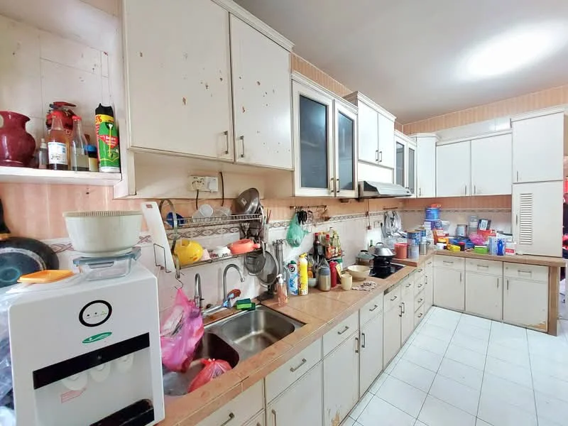 Kitchen features: white cabinetry with handles, laminate countertop, stainless-steel sink, chrome faucet, ceramic tile flooring, wall-mounted cabinets, built-in oven, microwave, various kitchen appliances, cluttered countertop with utensils and containers, tile backsplash, recessed lighting, multiple storage compartments.