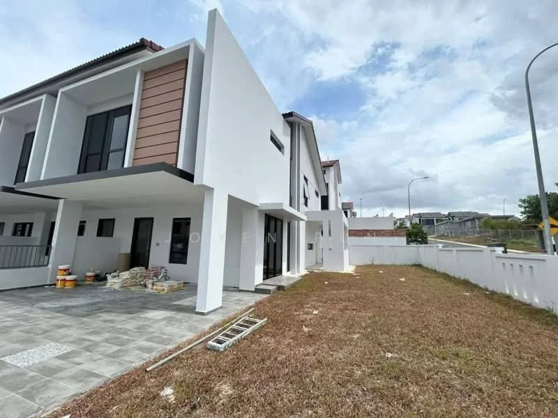 Exterior type: semi-detached house; features: white painted facade, brown accent panels, flat roof, two-storey structure, manicured lawn, paved walkway, visible construction materials on the ground, surrounded by low fencing, urban context with nearby roads; style: modern.
