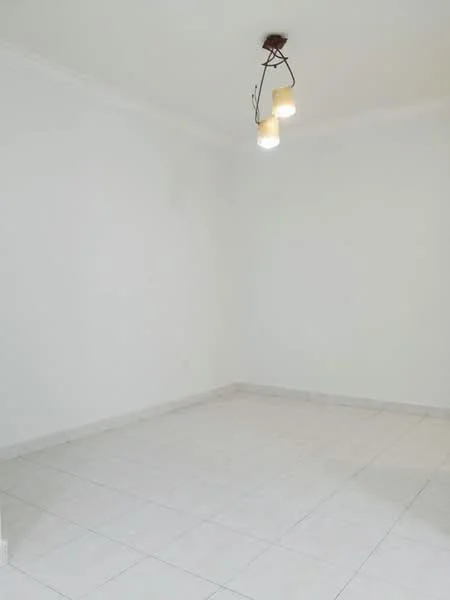 Room features: white painted walls, tile flooring, ceiling light fixture with three bulbs, no visible furniture or decor.