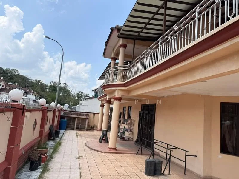 Exterior type: detached bungalow; features: two-storey building, balcony with railing, terracotta tiled flooring, white painted facade, red accent trim, covered porch area, manicured garden area, outdoor lighting fixtures, paved walkway, fenced perimeter, street lamp, visible parking area; style: modern.