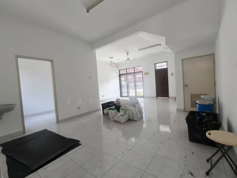 Room features: white painted walls, glossy white tile flooring, 2 ceiling fans, large windows, double-door entrance, door with security grill, sink, stack of bags, black plastic storage bin, folding table, black mat on floor.