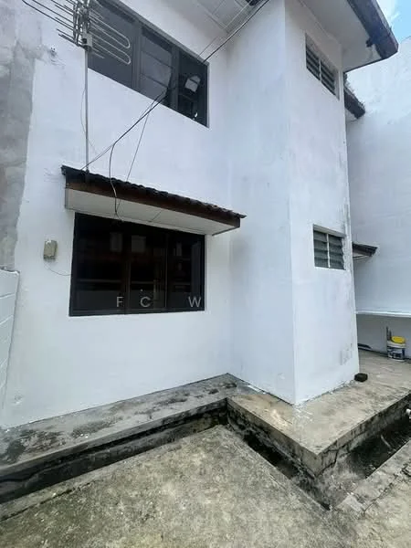 Exterior features: white painted facade, flat roof, single-storey, concrete flooring, window with metal grille, exposed electrical wiring, small overhang above window, concrete wall, drainage area; style: minimalist.
