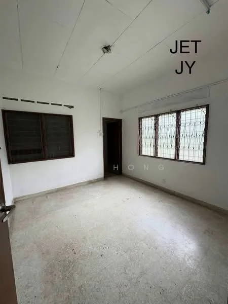 Room features: white painted walls, concrete flooring, two windows with metal grills, single ceiling light fixture, no visible furniture, plain ceiling, neutral color scheme, no visible decor; style: minimalist.