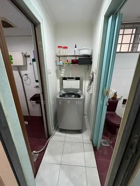 Room features: white painted walls, tile flooring, washing machine, shelf with containers, toilet, sink, shower area, doorways leading to other rooms.