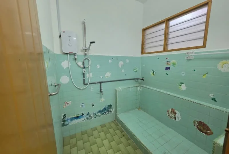 Bathroom features: green tiled walls, white shower head, handheld shower, grab bars, built-in bench, window with frosted glass, green tiled flooring, decorative wall stickers.
