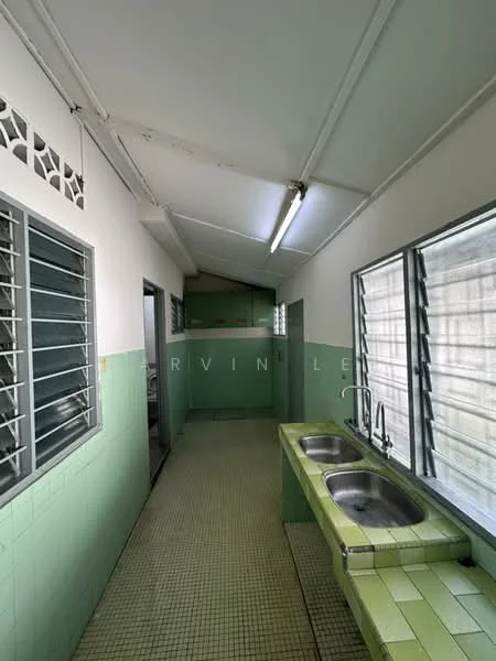 Kitchen features: green tiled walls, white painted walls, green tiled flooring, double-bowl stainless-steel sink, chrome pull-down faucet, window with metal grilles, fluorescent ceiling light, open layout, counter space, wall-mounted cabinets.