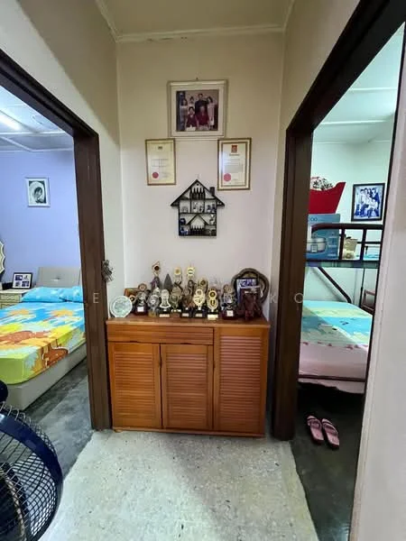 Room features: wooden console cabinet with louvered doors, trophies and awards displayed on cabinet, framed photographs on wall, two doorways leading to other rooms, decorative wall art, tile flooring, ceiling fan, slippers on the floor.