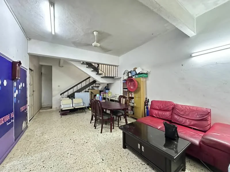 Living features: red leather sofa, wooden dining table with chairs, coffee table, ceiling fan, exposed concrete ceiling, terrazzo flooring, staircase, wall-mounted storage unit, wall with painted surface, light fixtures.
