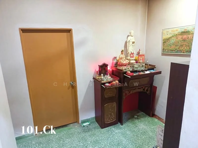 Room features: green speckled flooring, cream painted walls, wooden door, decorative altar table, statue on altar, candles on altar, framed artwork on wall, small offerings on altar; style: traditional.