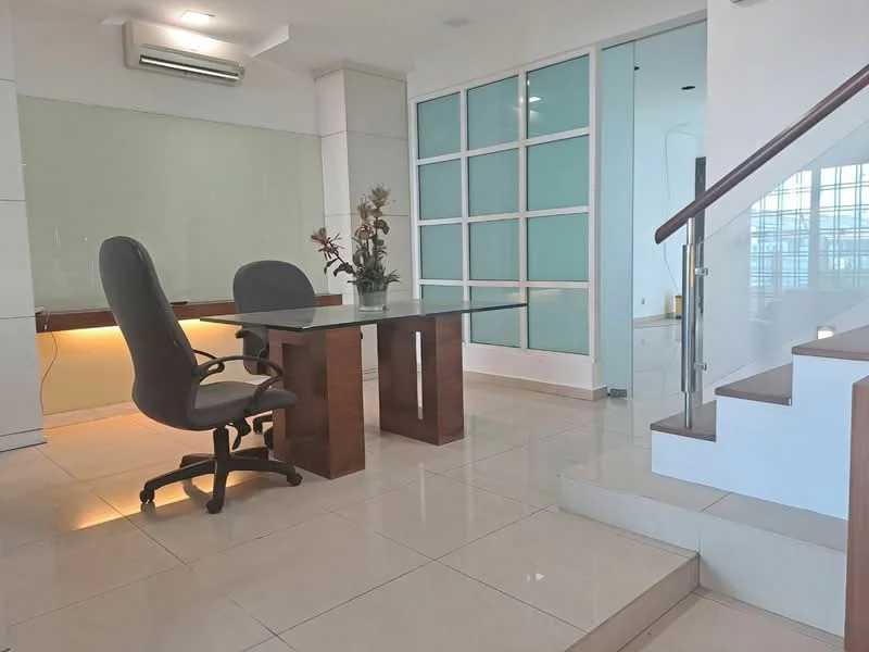 Study features: glass-top desk, ergonomic office chair, white painted walls, tile flooring, wall-mounted air conditioning unit, built-in glass panel sliding doors, staircase with wooden railing, decorative plant in vase, ambient lighting under desk, large windows providing natural light; style: modern.