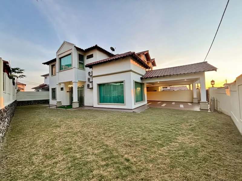 Exterior type: detached bungalow; features: white painted facade, sliding glass windows, green tinted glass windows, pitched tile roof, manicured lawn, stone-paved walkway, 2 wall-mounted split ACs, car porch with awning, outdoor lighting, fenced perimeter, landscaped garden; style: modern.