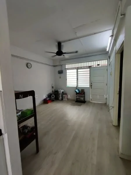 Room features: light-colored laminate flooring, white painted walls, ceiling fan, window with horizontal slats, door with glass panel, wall clock, open shelving unit, natural light from window; style: minimalist.