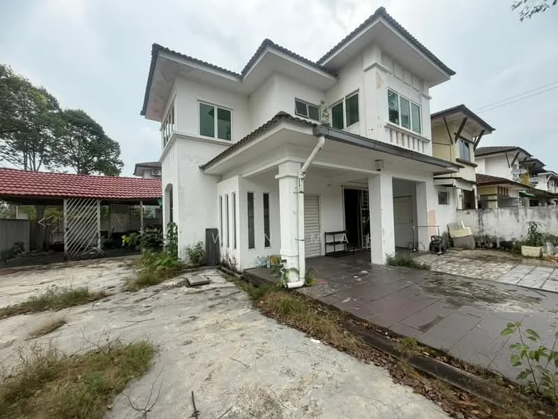 Exterior type: detached bungalow; features: white painted facade, flat roof, two-storey structure, large windows, porch area, paved driveway, surrounding greenery, overgrown landscaping, adjacent carport, exposed concrete flooring, fenced perimeter; style: modern.