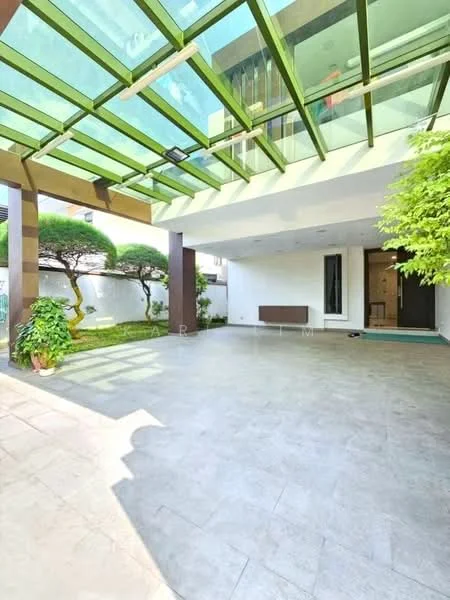Exterior type: detached bungalow; features: glass roof with green framing, open patio area, stone-paved flooring, manicured garden with shrubs, exterior wall with white finish, large windows, modern architectural design, outdoor space with natural light; style: modern.