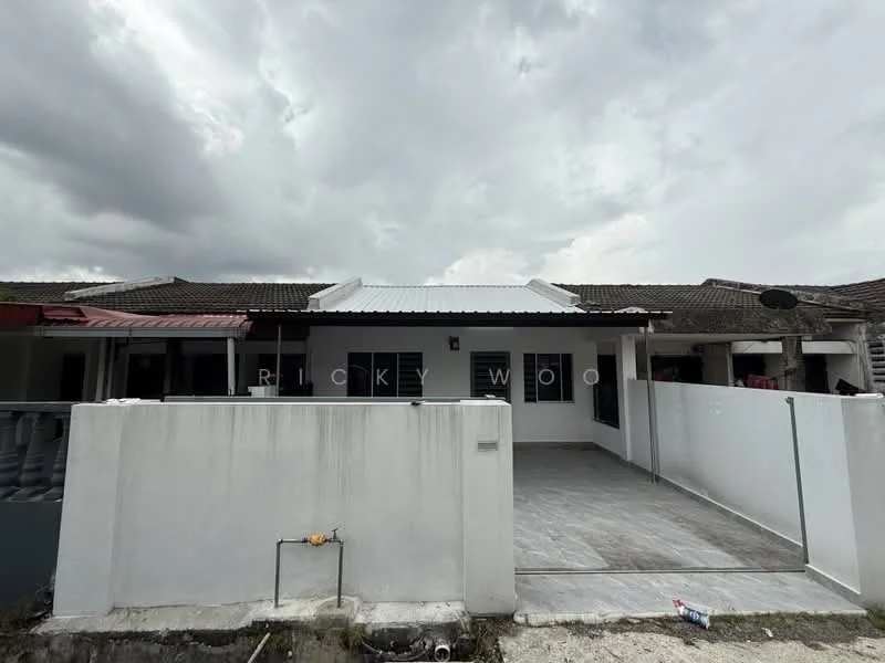 Exterior type: linked terrace house; features: white painted facade, flat roof, single-storey, paved driveway, front porch area, grey tiled flooring, surrounded by low fencing, gutter system visible, overcast sky; style: modern.