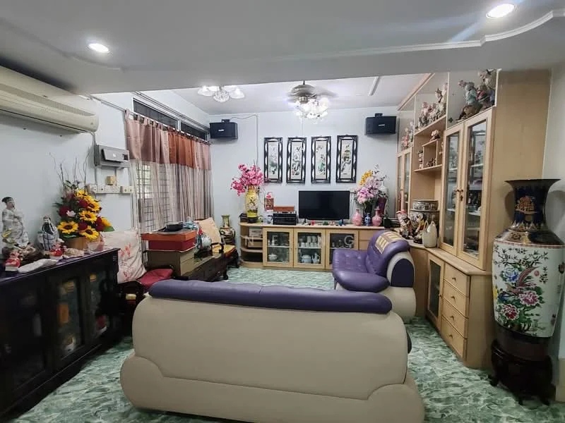 Living features: 3-seater sofa in cream and purple, coffee table, TV console with television, built-in cabinets, decorative vases, wall-mounted speakers, air conditioning unit, ceiling fan with light, green patterned flooring, framed artwork on walls, decorative flowers, curtains, shelves with collectibles; style: traditional.
