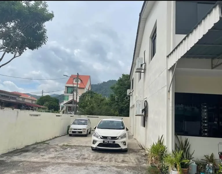 Exterior type: detached bungalow; features: white painted facade, flat roof, two-storey building, manicured lawn, paved driveway, parking space for two cars, surrounded by greenery, mountain view in background; style: modern.